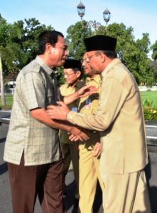 H Muhammad Nur bersalaman dengan Asisten II Bidang Ekonomi dna Pembangunan, H Lalu Gita Ariadi; paripurna sebagai pegawai negeri 