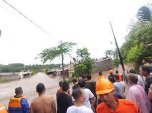 masyarakat menyaksikan perumahan yang terendam banjir